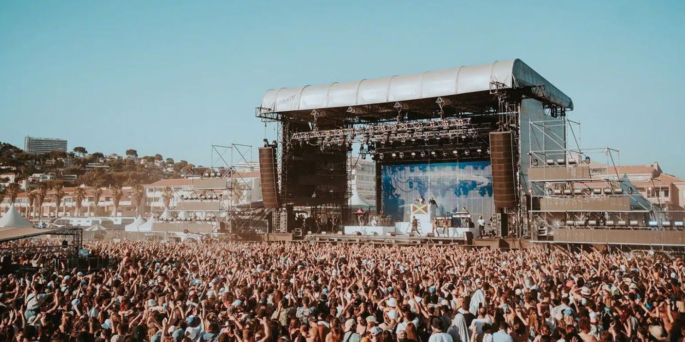 Vue panoramique du Delta Festival 2025 à Marseille, avec scène et spectateurs sur la plage