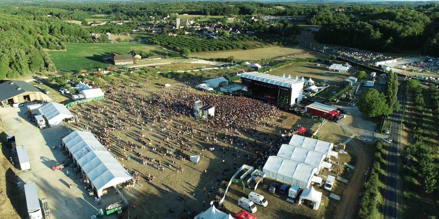 Vue aérienne du festival Ecaussystème 2025 avec grande scène et village éco-responsable