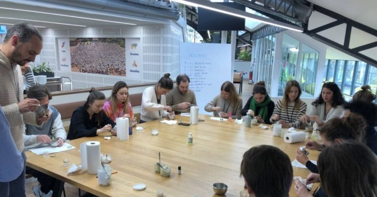 Atelier DIY zéro déchet lors d'un séminaire RSE, collaborateurs fabriquant des produits écoresponsables.