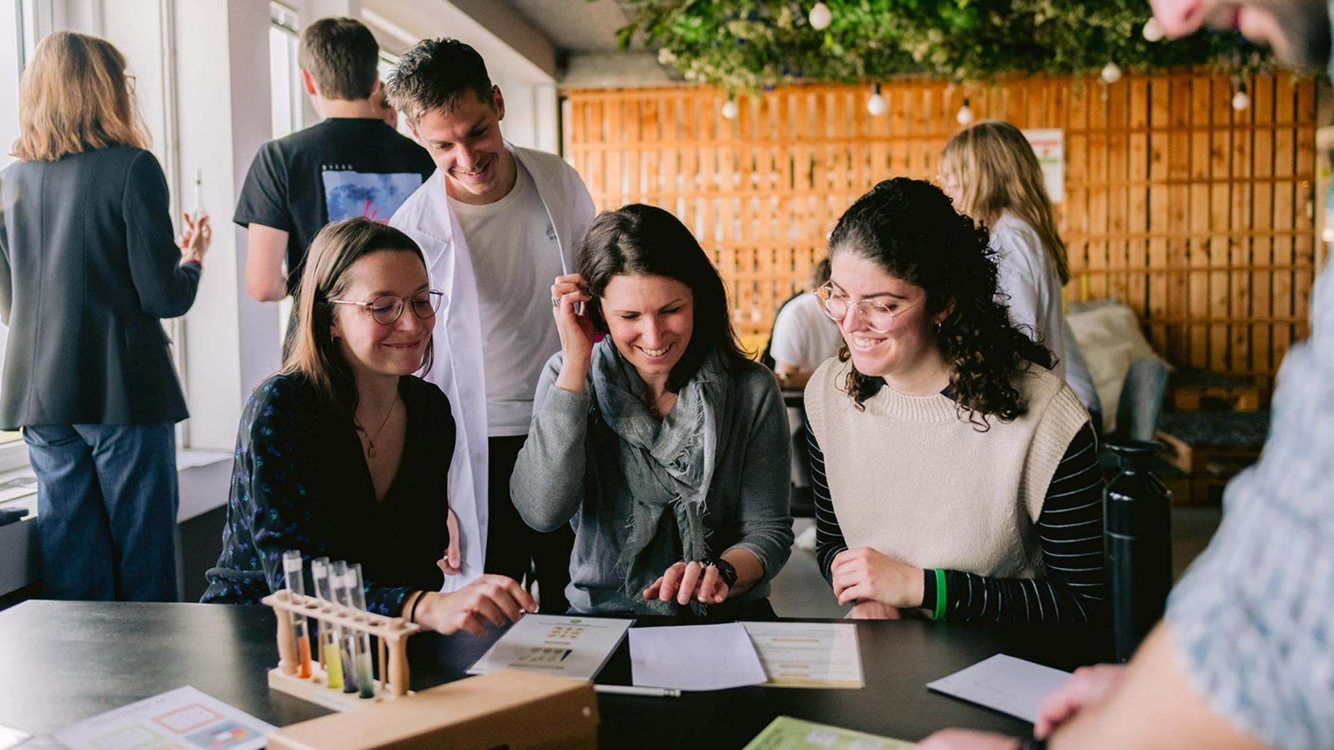 Participants souriants travaillant en équipe lors d’un escape game sur le thème du climat, favorisant la sensibilisation écologique et l’engagement RSE